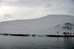 09C Zodiac About To Land On Danco Island With Tourists Climbing To The Top Of The Island On Quark Expeditions Antarctica Cruise.jpg